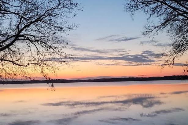 Sunset brings an orange sky reflect on Lake Waubesa